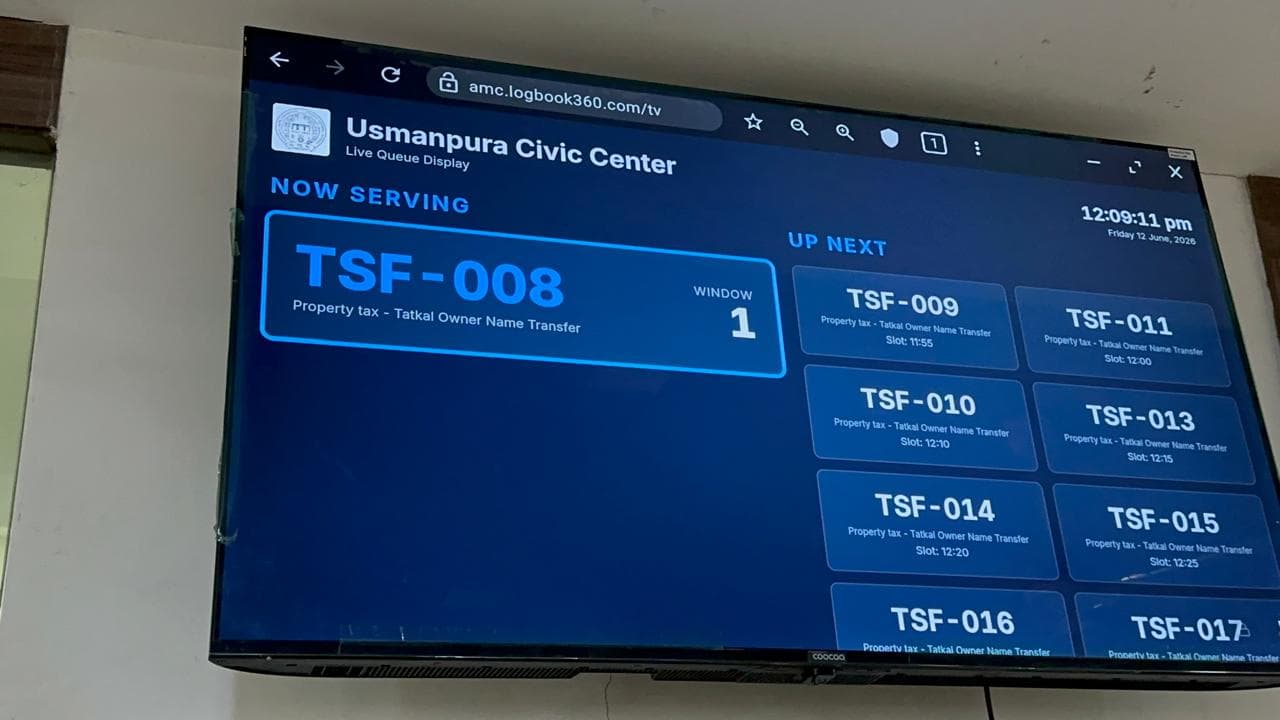 Live queue display at an AMC civic center showing the token now serving and the tokens up next