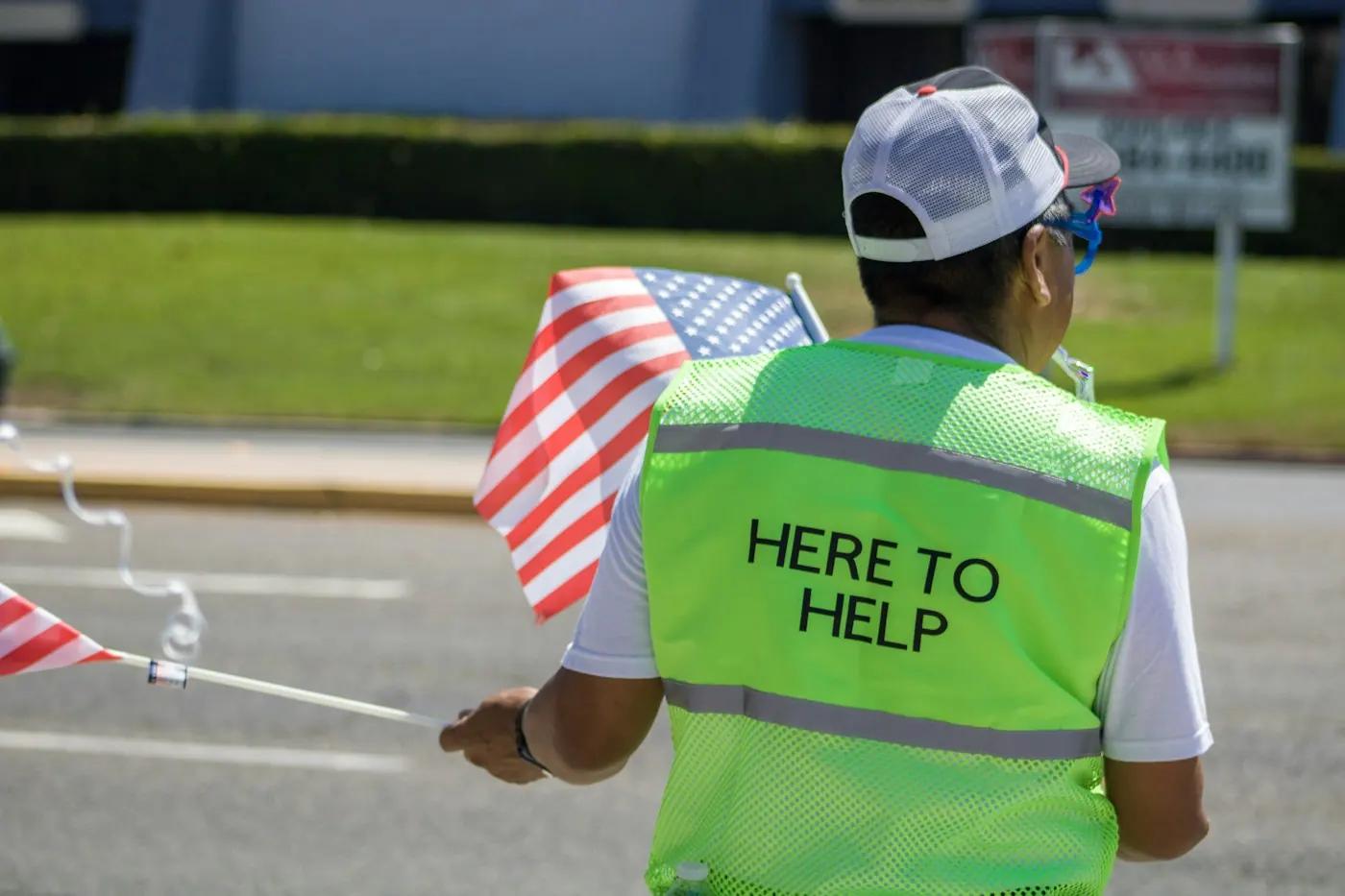 Volunteer in a high-visibility Here to help vest